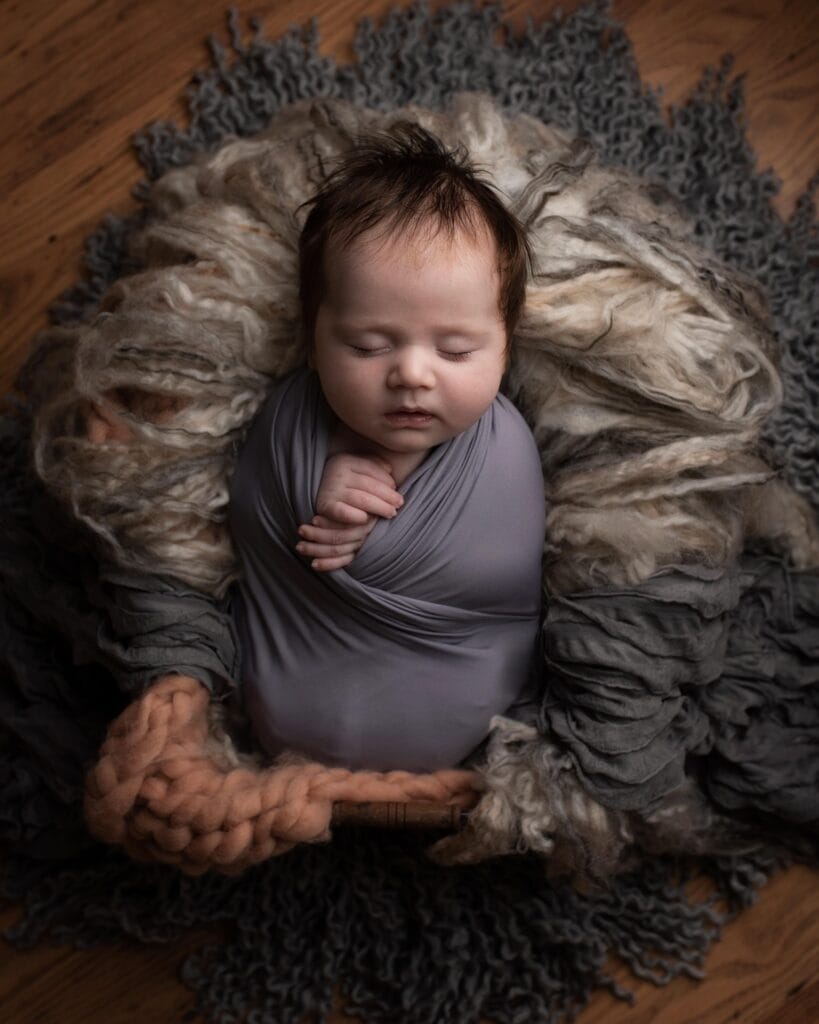 Newborn baby peacefully sleeping in a soft blanket